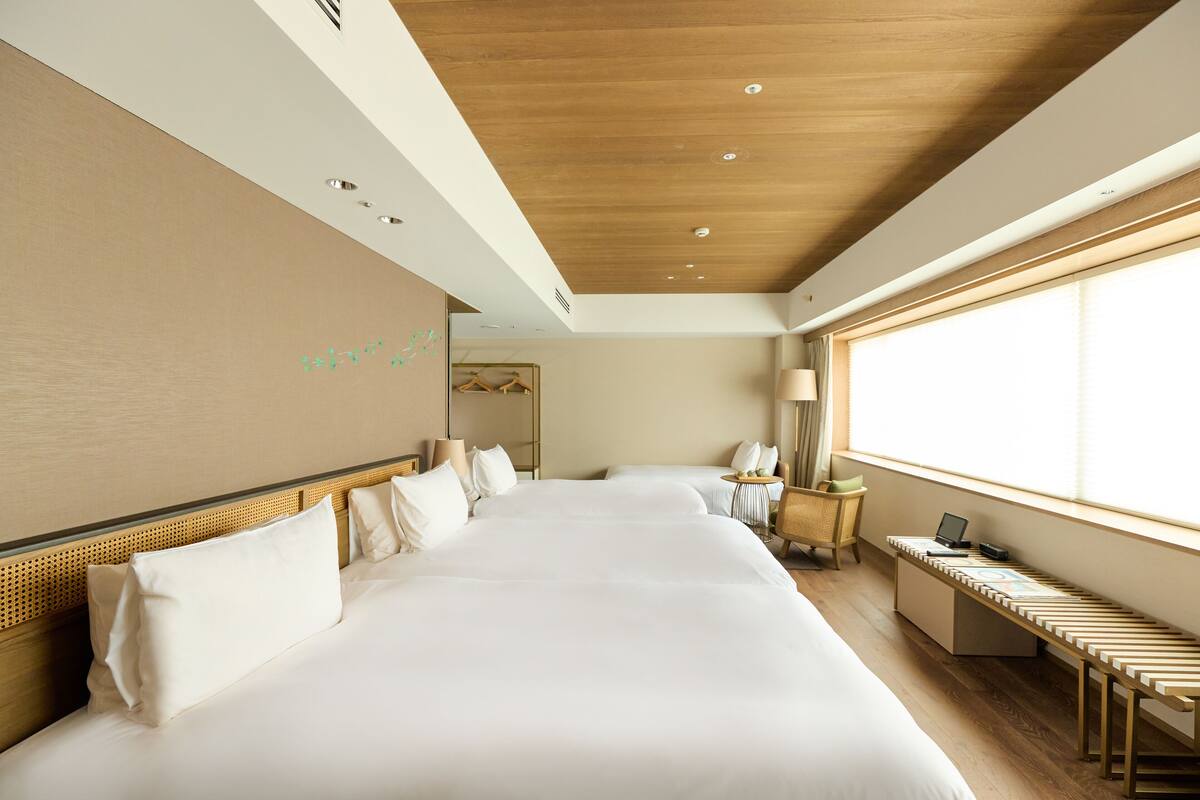 Ein Hotelzimmer mit einem großen Bett, einem Schreibtisch und einem Fenster.
