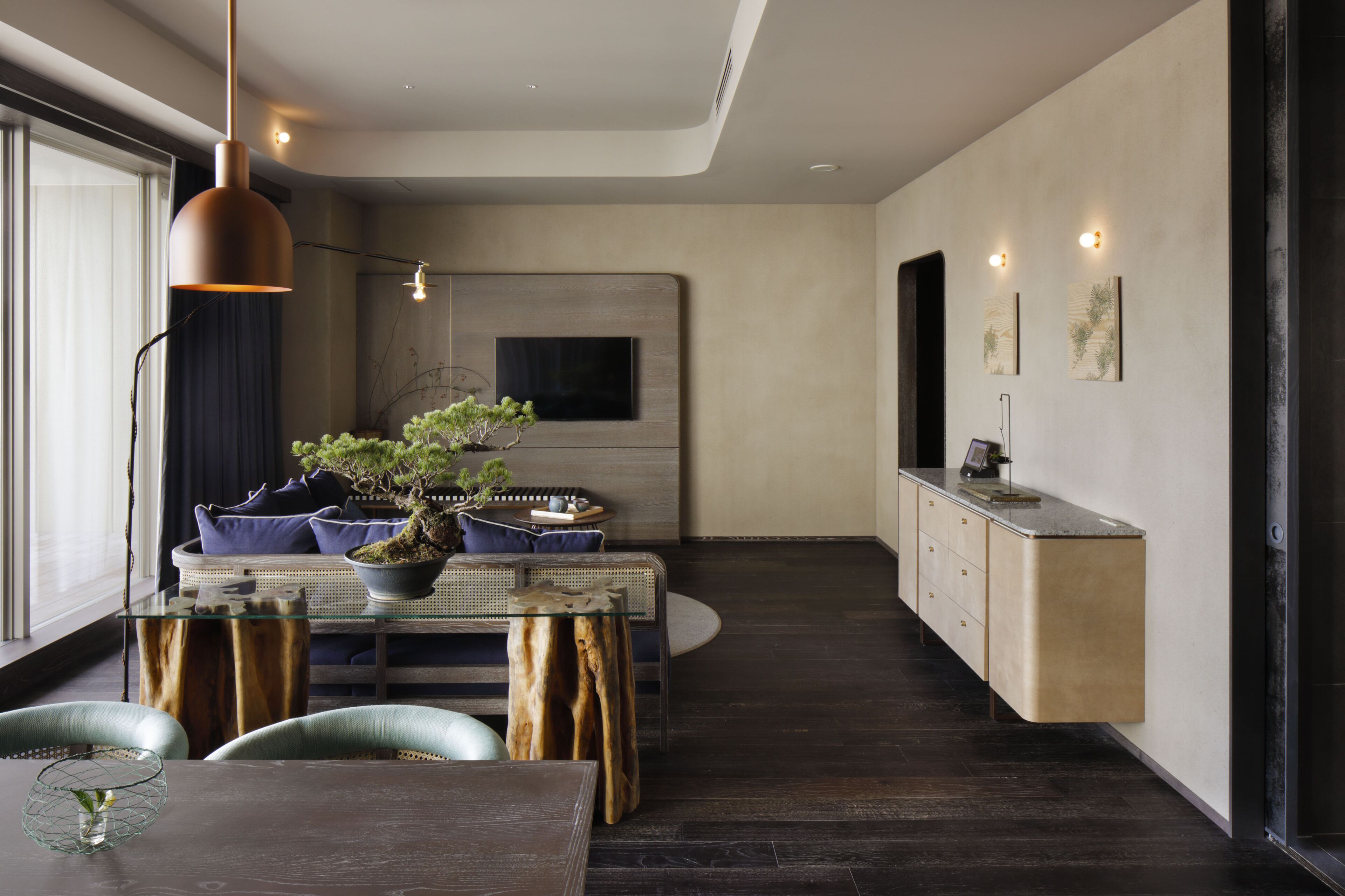Un espace repas moderne avec une table en bois, des chaises et une plante en pot.