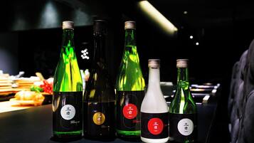 Une sélection de bouteilles, dont les étiquettes sont visibles, est exposée sur le comptoir d’un bar.