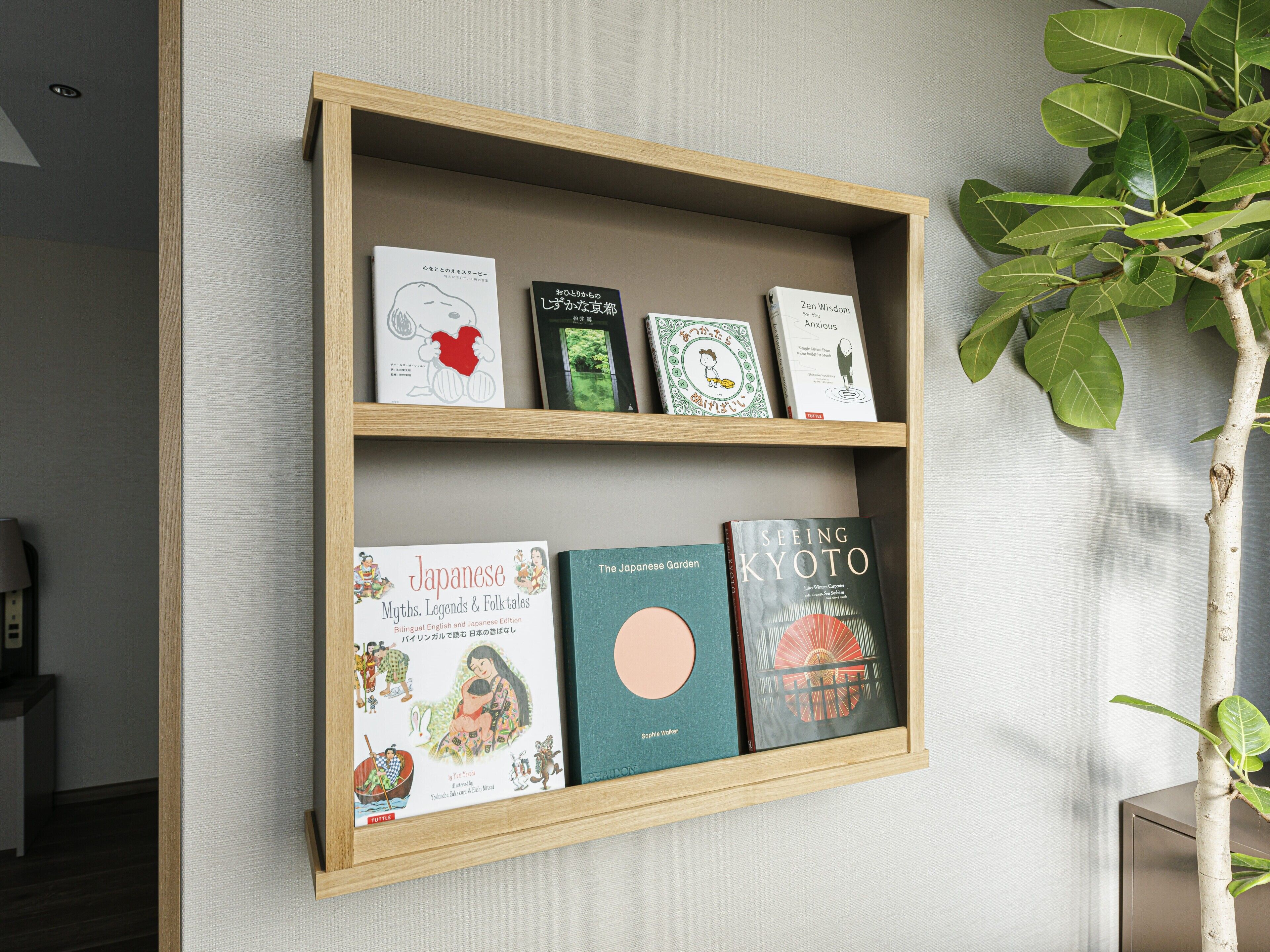 A wooden shelf with books and a potted plant.