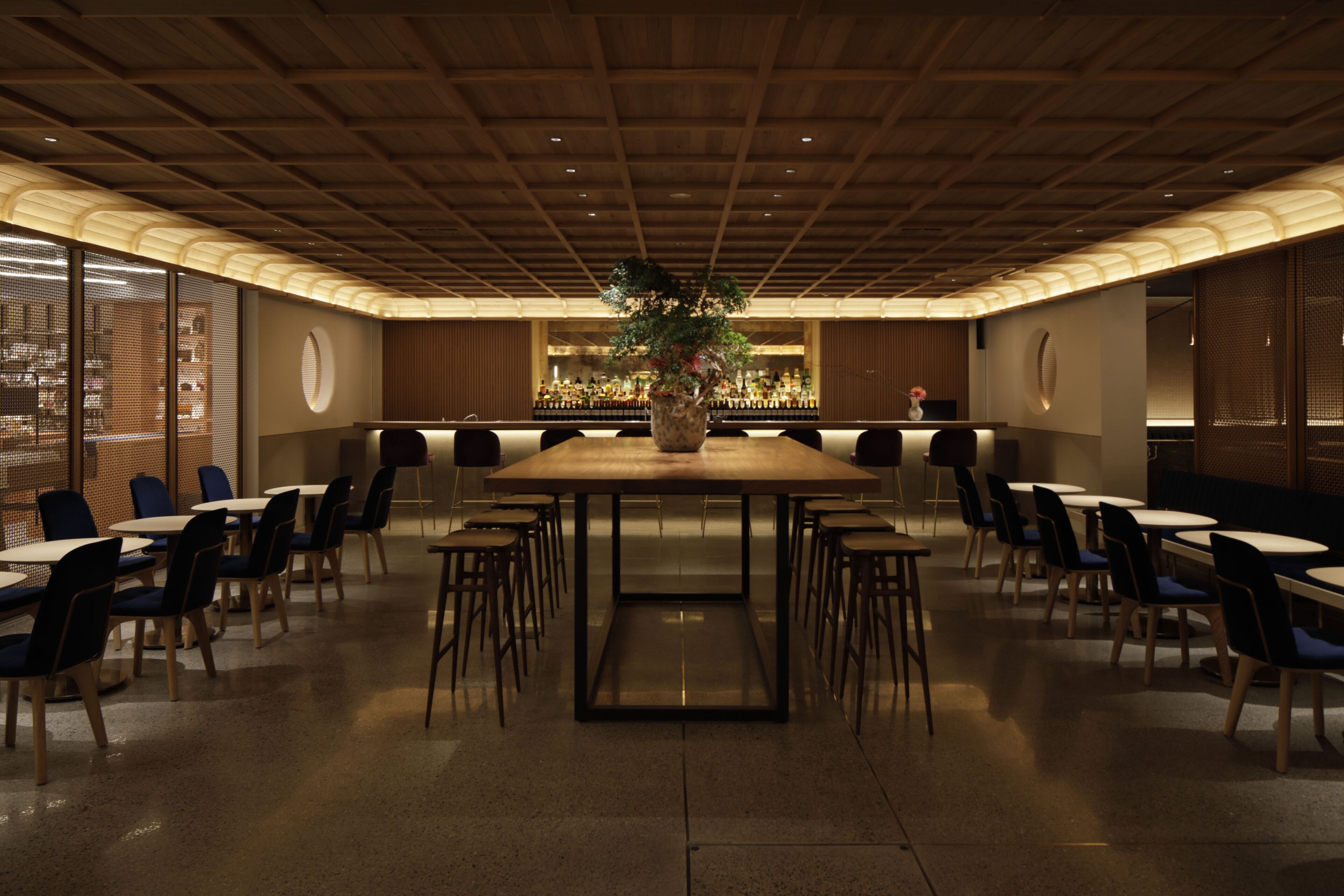 A conference room with a long table, chairs, and a decorative plant in the center.