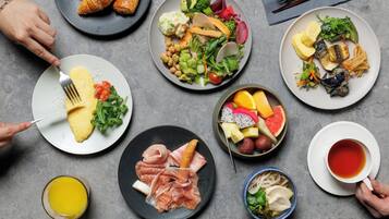 A table with various food items including eggs, salad, fruits, and a cup of tea.