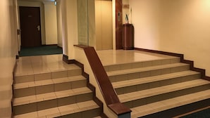 A staircase with a wooden handrail leading to a landing. - The Executive Hotel Lahad Datu (Lahad Datu)