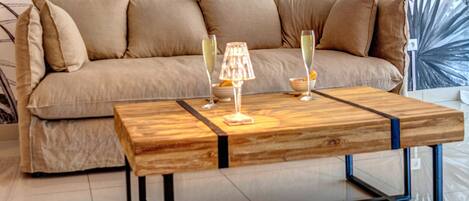 Un salon comprenant un canapé, une table basse en bois et des objets de décoration.