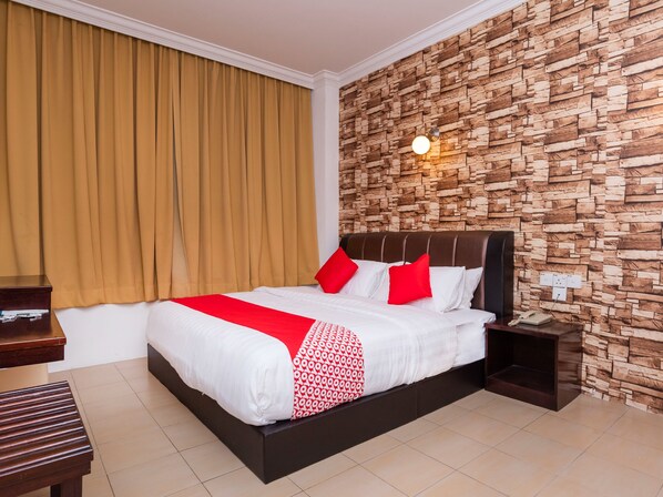 A hotel room with a bed, a nightstand, a telephone, and a wall with a stone-like texture. - Super OYO 1114 Neo Pegasus Hotel (Segamat)