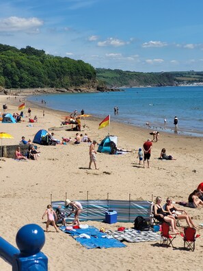 A beach with tents, chairs, and people.