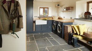 A compact kitchen with a washing machine, a sink, and a window.