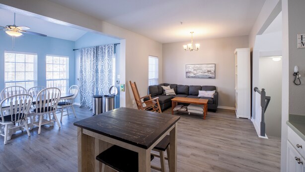 A spacious living area with a dining table, chairs, a sofa, and a coffee table. - Perfect family vacation, Open floor plan, Relaxed coastal living (Millville)