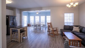 A spacious living area with a dining table, chairs, a sofa, and a wooden bench. - Perfect family vacation, Open floor plan, Relaxed coastal living (Millville)