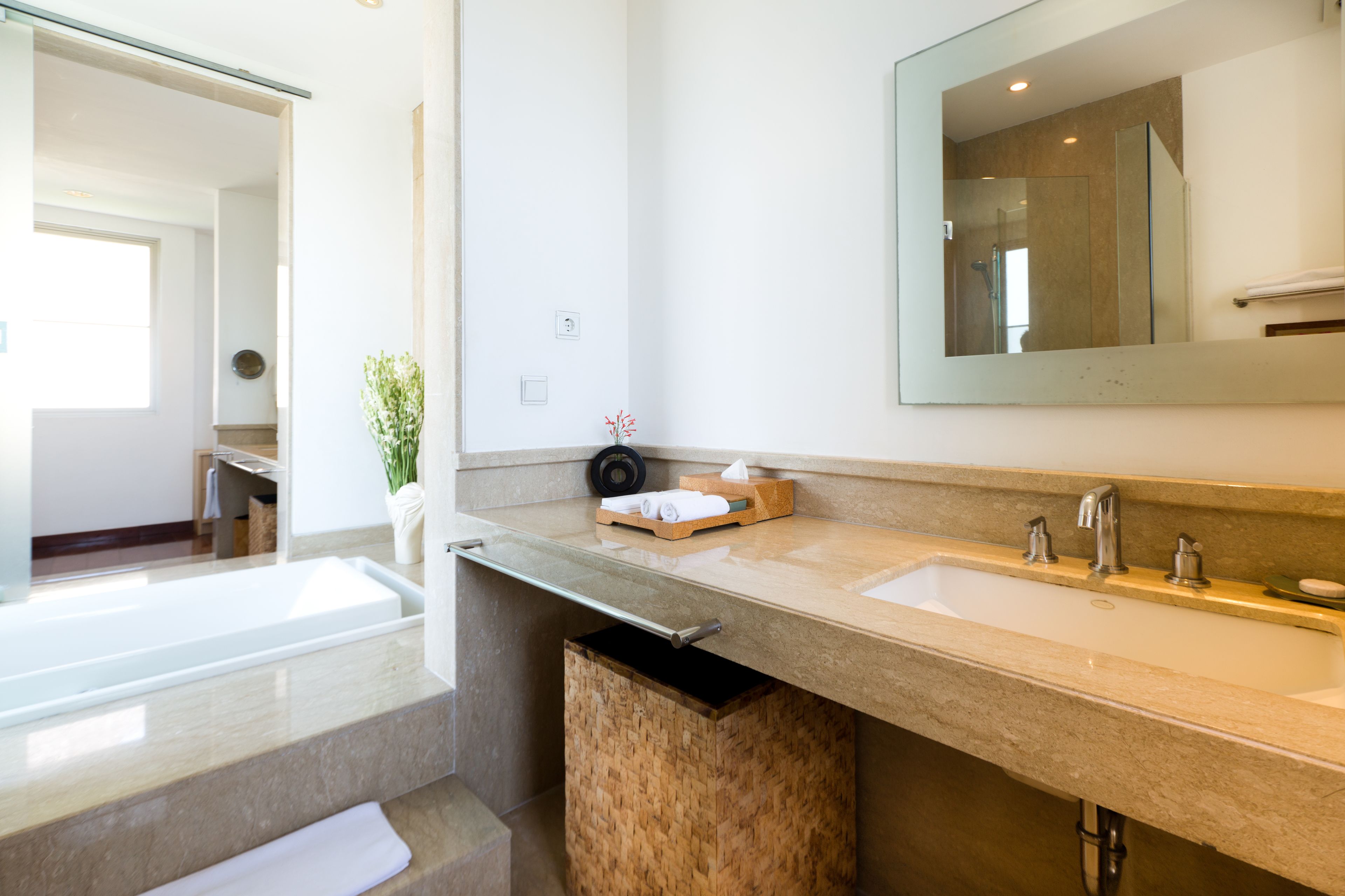 Une salle de bain moderne avec un grand miroir, deux lavabos et un meuble de rangement en bois.