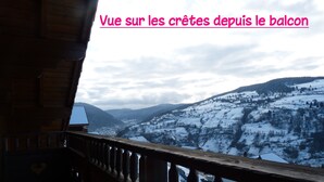 Varanda com vista para colinas nevadas e um vale.