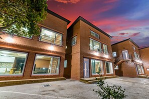 A multi-story residential building with large windows and a brick facade.