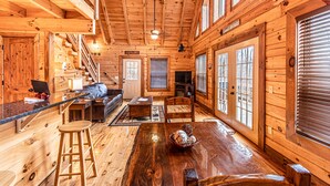 L’intérieur d’un chalet en bois comprend une cuisine, un coin repas et un salon.