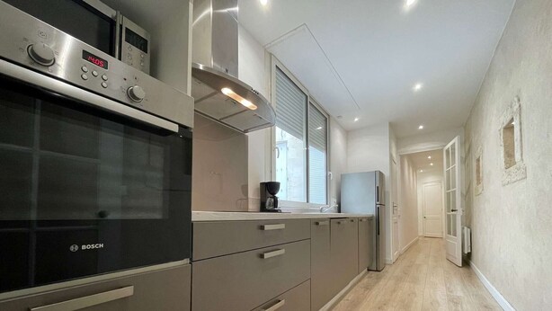 A modern kitchen with a Bosch oven, a built-in stove, and a stainless steel range hood.
