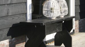 A wooden bench with two white lanterns on a wooden deck. - B&B depolderschuur is an independent home (Tienhoven)