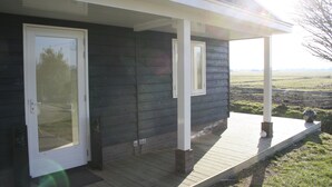 A house with a covered porch, a door, and a window. - B&B depolderschuur is an independent home (Tienhoven)