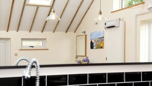 Een badkamer met dakraam, spiegel, schilderij en een moderne kraan.