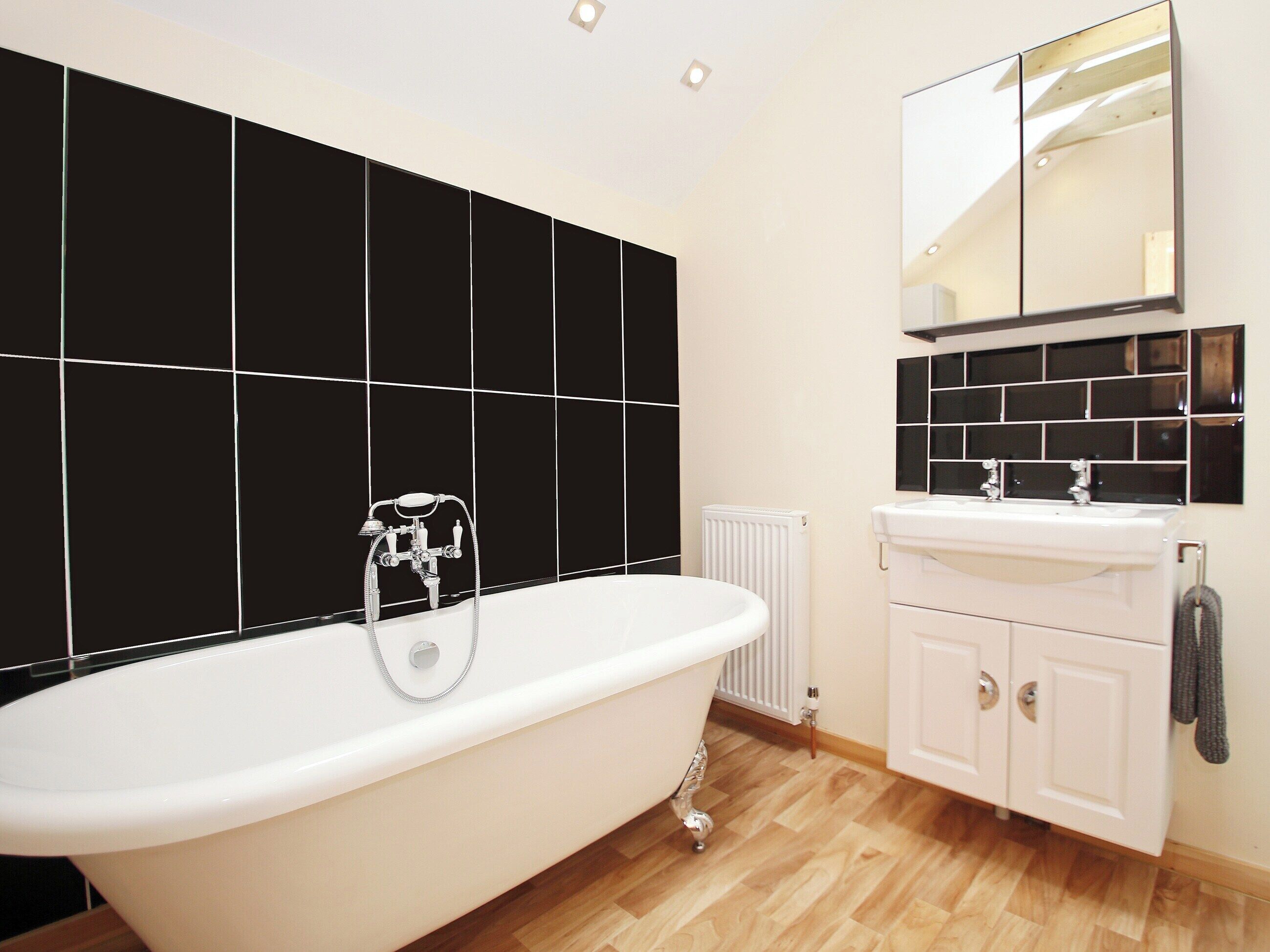 A bathroom with a freestanding bathtub, a white sink, and a mirror above the sink.
