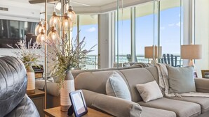Ein modernes Wohnzimmer mit einer Couch, einem Tisch mit Lampe und einem großen Fenster mit Blick.