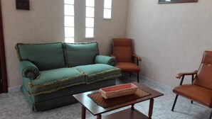 A living room with a green sofa, an orange armchair, and a wooden coffee table. - Vacation home !! (Trappeto)