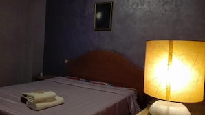 A hotel room with a bed, a nightstand, a lamp, and a framed picture on the wall. - Vacation home !! (Trappeto)
