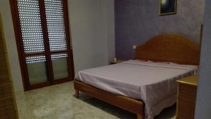 A bedroom with a bed, a nightstand, a dresser, and a window with blinds. - Vacation home !! (Trappeto)