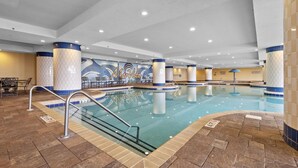 An indoor swimming pool with tiled walls, a mural, and multiple columns. - MVG 1116 4 Bedroom Ocean View (North Myrtle Beach)