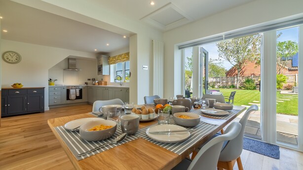 A modern kitchen with a dining area, large windows, and a view of the backyard. - Stone Croft, Barney, Norfolk (Barney)