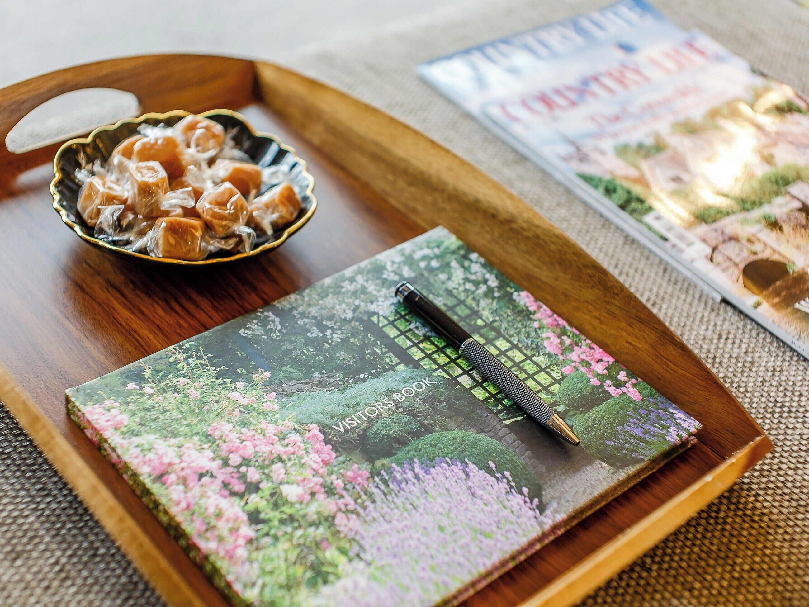 Un plateau en bois avec un bol de collations et un carnet à motifs floraux.