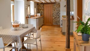 Un comedor con una mesa, sillas y techo de madera.