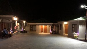 A spacious outdoor area with a building in the background. - BTV Guesthouse (Mbombela)