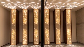 Un interior moderno con seis paneles altos y estrechos, iluminados, sobre una pared.