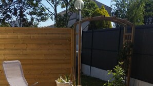 A wooden deck with a lounge chair, potted plants, and a wooden pergola. - QUIET AND SERENITY - SEASIDE (VAUX SUR MER)