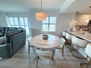 Una cocina moderna con comedor, ventanas amplias y un sofá.