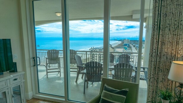 A balcony with a view of the ocean and a cityscape.