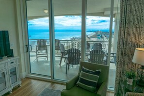 A balcony with a view of the ocean and a cityscape.