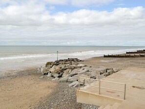 A rocky beach with a concrete walkway leading to the sea. - 2 bedroom accommodation in Tywyn (Tywyn)