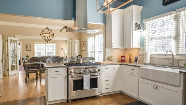 A modern kitchen with white cabinets, a stainless steel stove, and a large window. - The most beautiful home in Historic East Side of Kalispell. @whitehouse_project  (Kalispell)
