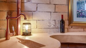 A bathroom with a copper faucet, a lit lantern, wine glasses, and a bottle of ZABACO wine. - The most beautiful home in Historic East Side of Kalispell. @whitehouse_project  (Kalispell)