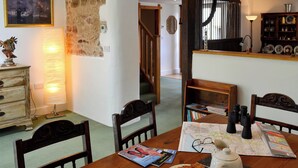 A dining area with a wooden table, chairs, a map, and a coffee pot. - 2 bedroom accommodation in Kentisbeare, Cullompton (Kentisbeare, Cullompton)