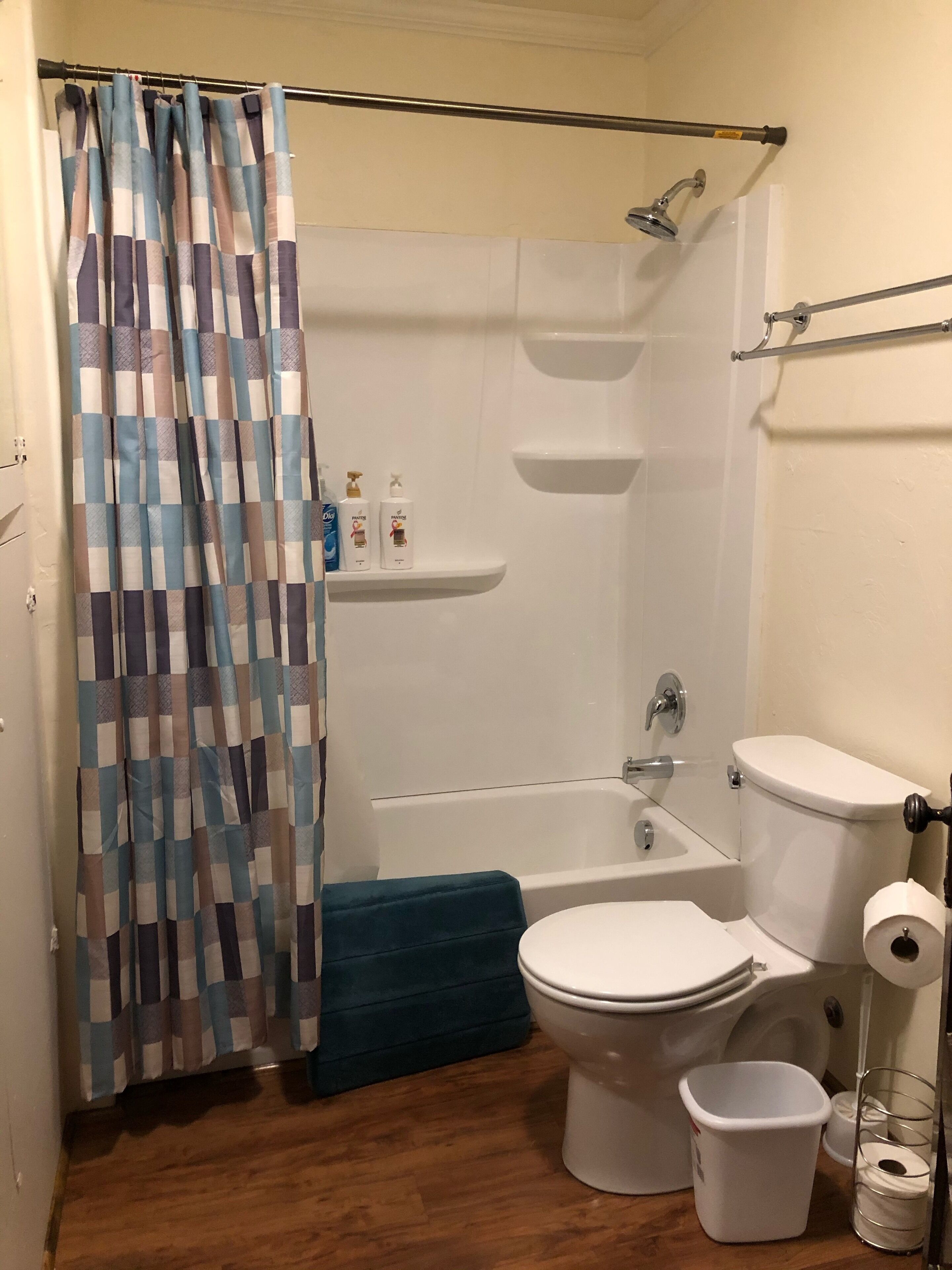 A bathroom with a shower, toilet, and a small sink.
