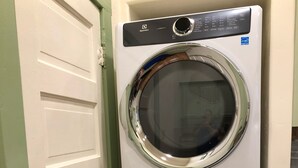 A stacked washer and dryer unit with a control panel, a door, and a green door frame.
