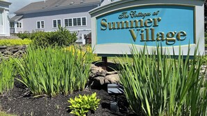 Une enseigne indiquant « The Cottages at Summer Village », avec un bâtiment en arrière-plan.