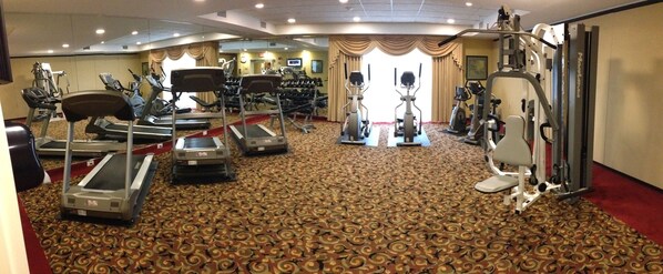 A gym with treadmills, elliptical machines, and weight machines.