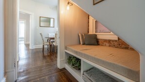 A room with a built-in bench, a mirror, and a staircase.