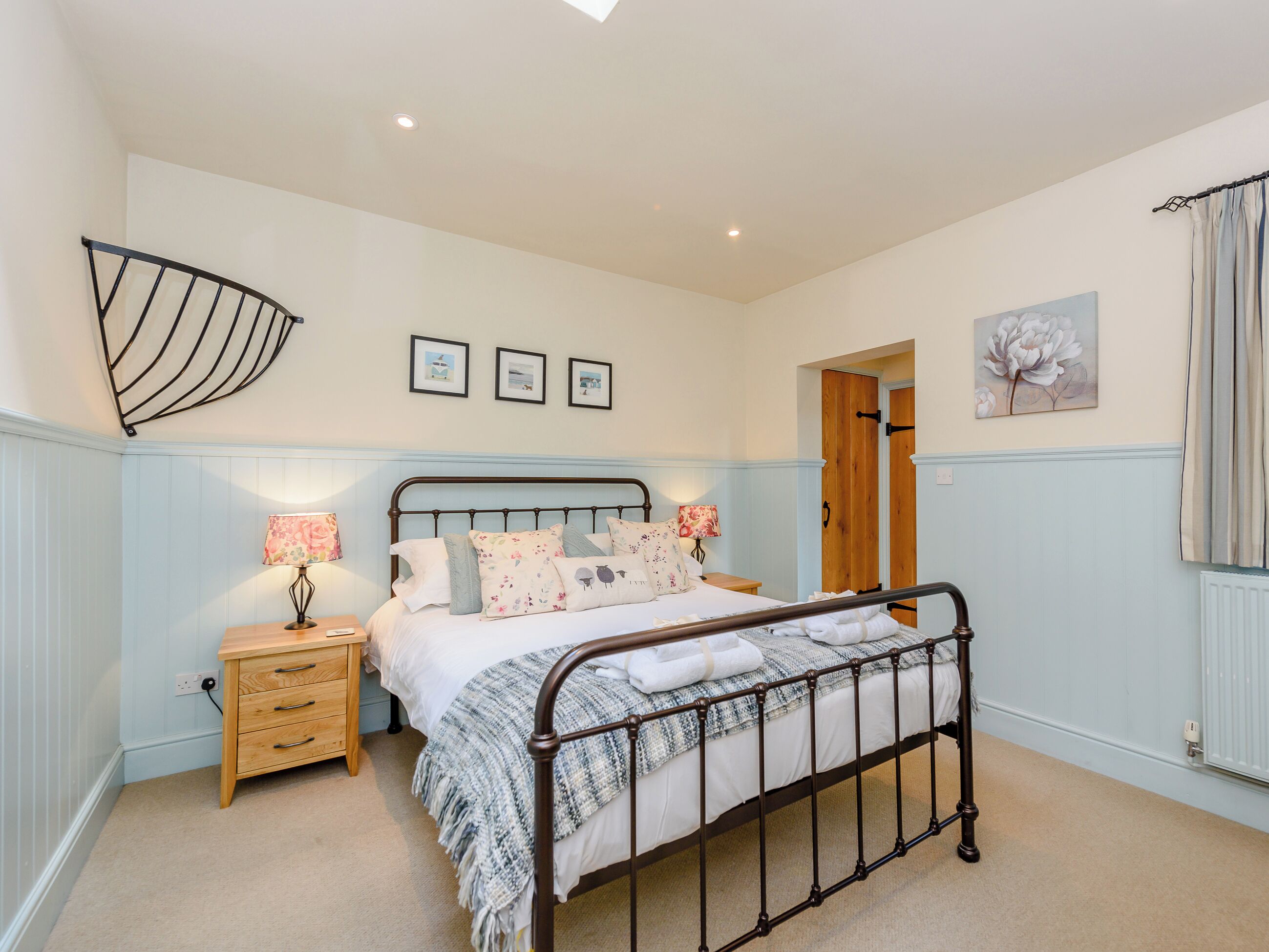 A bedroom with a bed, bedside tables, a wardrobe, and a ceiling fan.