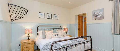 A bedroom with a bed, bedside tables, a wardrobe, and a ceiling fan.