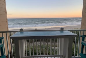 A balcony with a view of the ocean and beach.