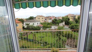 A balcony with a view of a residential area, a tiled floor, and a potted plant. - SORRISO 2 Two-Bedroom Apartment (Rovinj)