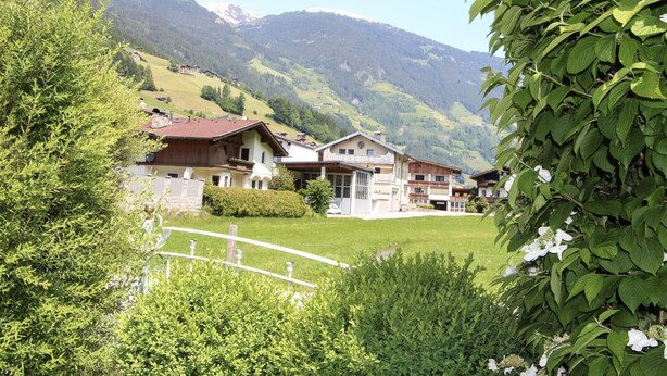 A mountain village with traditional wooden houses, a grassy courtyard, and a white fence. - Beautiful apartment for 6 people with WIFI, TV, terrace and panoramic view (Hippach)